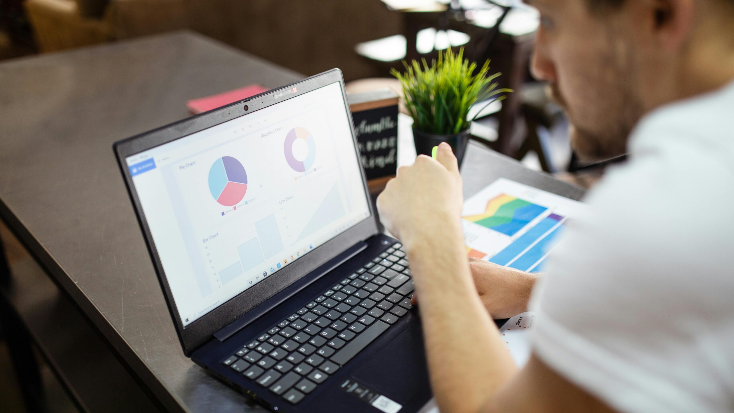 Man reviewing charts and graphs on a laptop for business analysis.